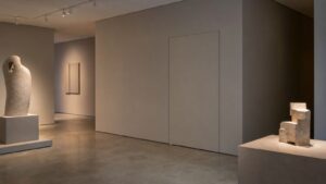 A realistic museum gallery with a concealed service entrance integrated into a clean wall and no readable labels.