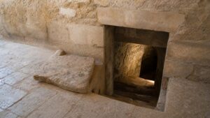 A realistic underground stone passage with a concealed entrance from a plain surface room and no readable markings.