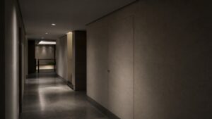 A realistic editorial image of a discreet secure corridor entrance inside a restrained intelligence-office setting.